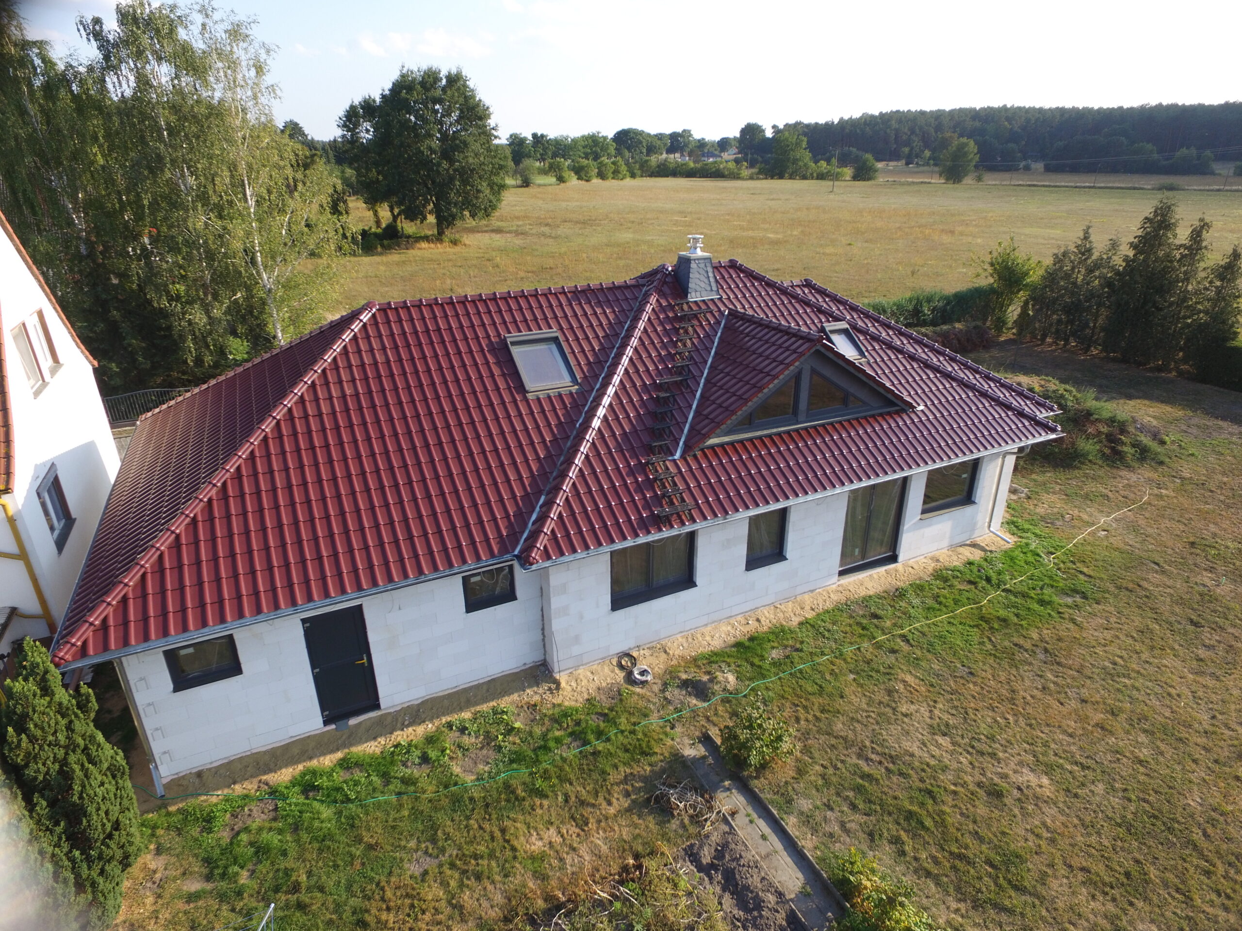 Langes Gebäude mit neu saniertem rotem Dach.