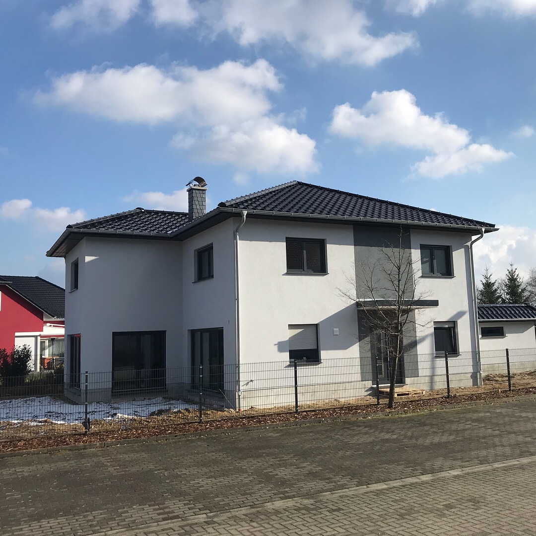 Modernes Einfamilienhaus mit Flachdach und heller Fassade.