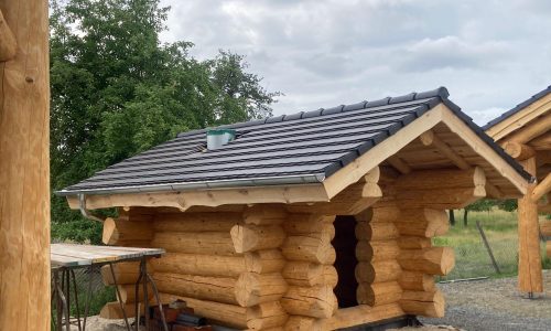 Fertiggestelltes Blockhaus mit passendem Dach und Holzfassade.