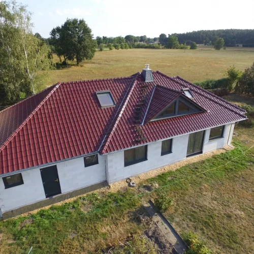Langes Gebäude mit neu saniertem rotem Dach.