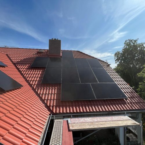 Rotes Ziegeldach mit montierter Photovoltaikanlage durch den Dachdecker.