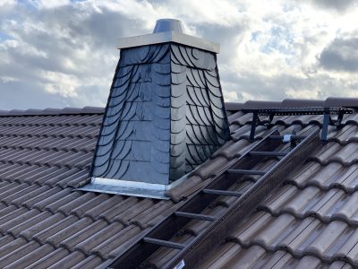 Schornstein mit Schieferverkleidung passend zur Dacheindeckung.