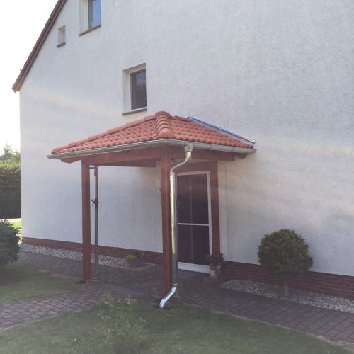 Vordach mit Ziegeleindeckung an einem Einfamilienhaus.